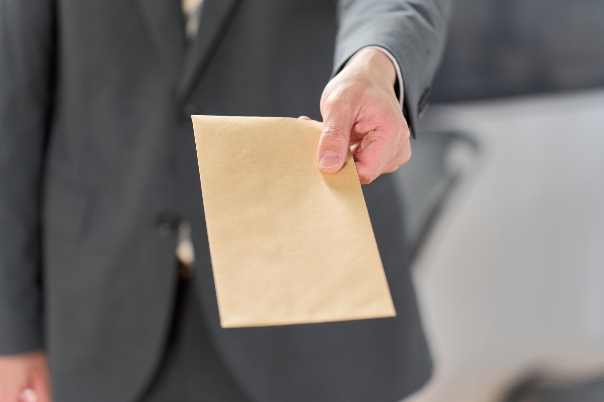 Businessman holding out an envelope