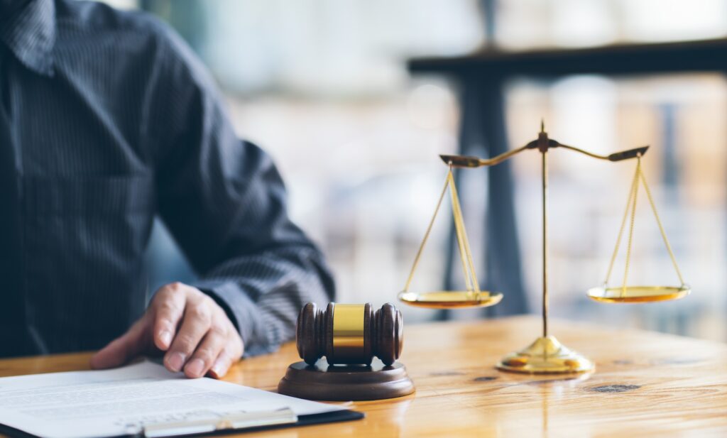 Business and lawyers discussing contract papers with brass scale on desk in office. Law, legal serv